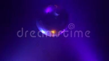 3D迪斯科镜球在烟雾中反射五颜六色的灯光